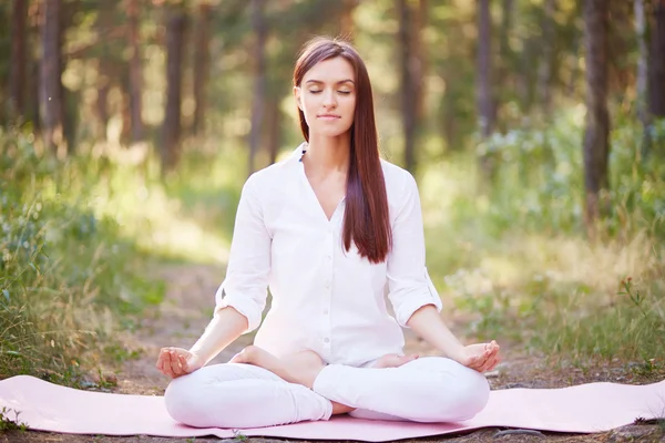 Woman meditating in the woods