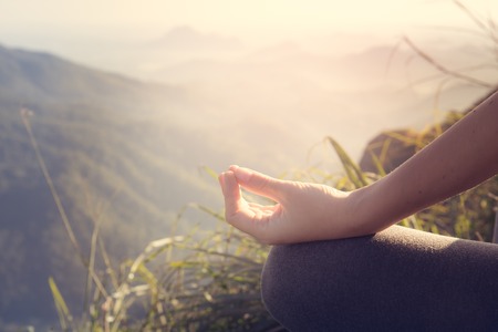 107990943-young-woman-meditating-on-top-of-a-mountain