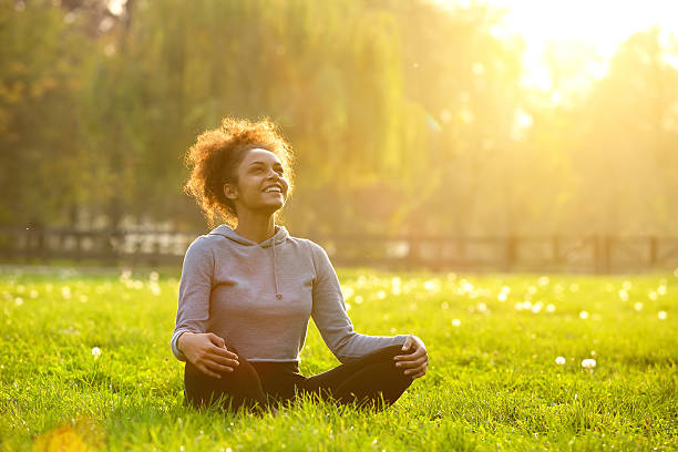 Woman sitting in grass practicing yoga