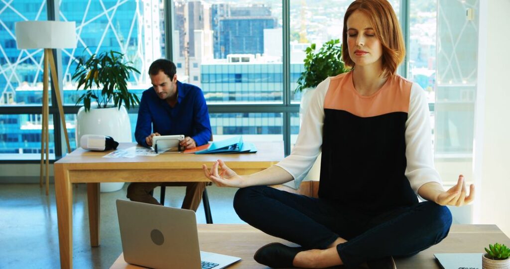 woman meditating on desk at work