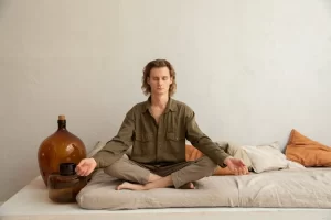 Serene man siting in lotus position, practicing lotus yoga